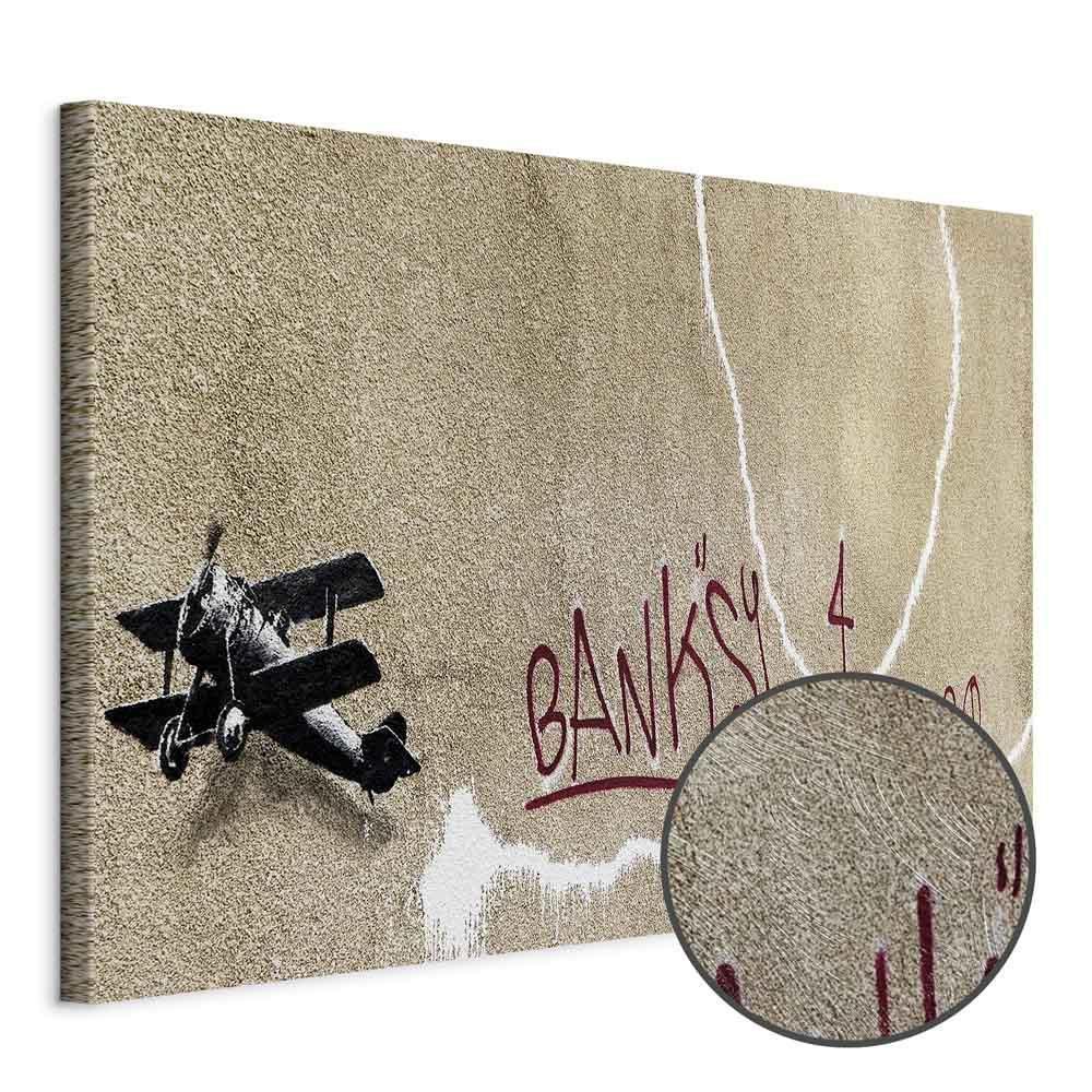 Leinwandbild - Banksy's Plane (1-part) - Red Graffiti Text on Mural Background
