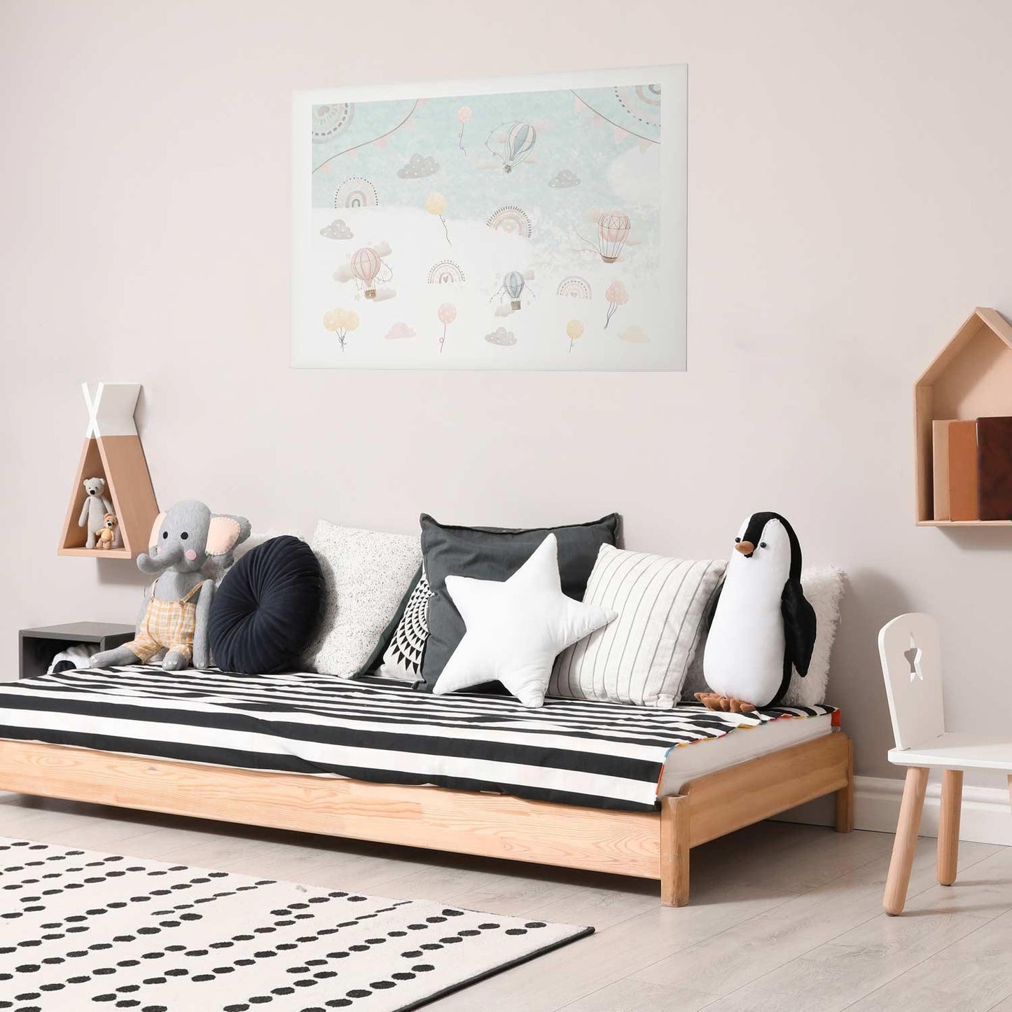 Adventure Among the Clouds poster in a modern children's room with stuffed toys and striped bedding.