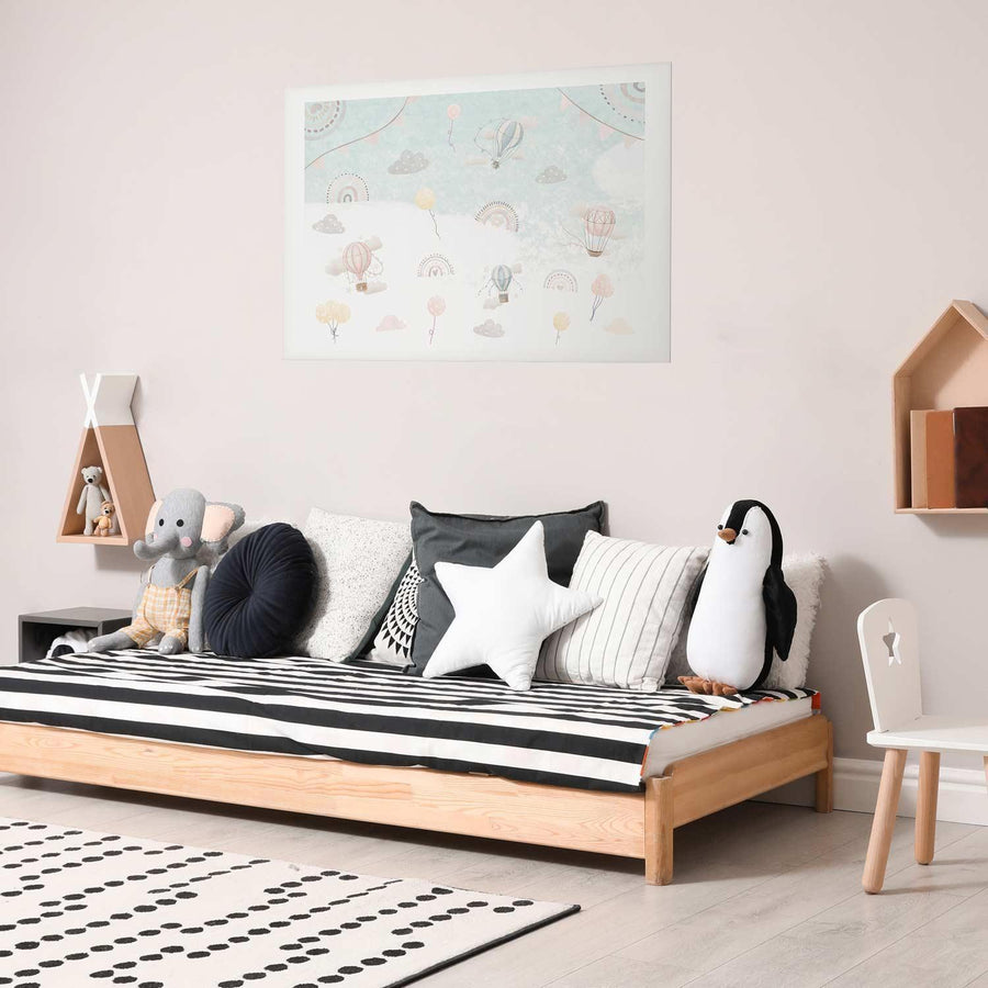 Adventure Among the Clouds poster in a modern children's room with stuffed toys and striped bedding.