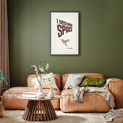 Poster titled "I Need More Space" on a green wall in a cozy living room setting.
