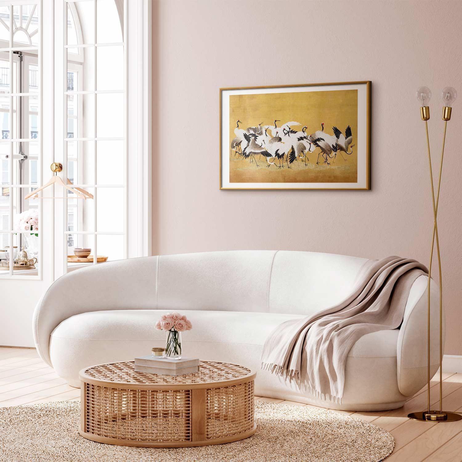 Japanese cranes poster with golden background in modern living room setting.