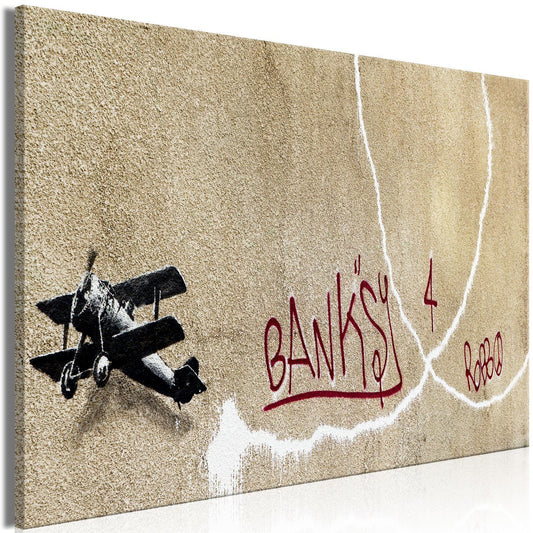 Leinwandbild - Banksy's Plane (1-part) - Red Graffiti Text on Mural Background Artgeist