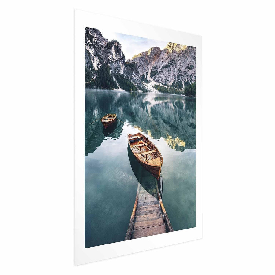 Poster of wooden boats on a calm lake in the Dolomites with mountain backdrop.
